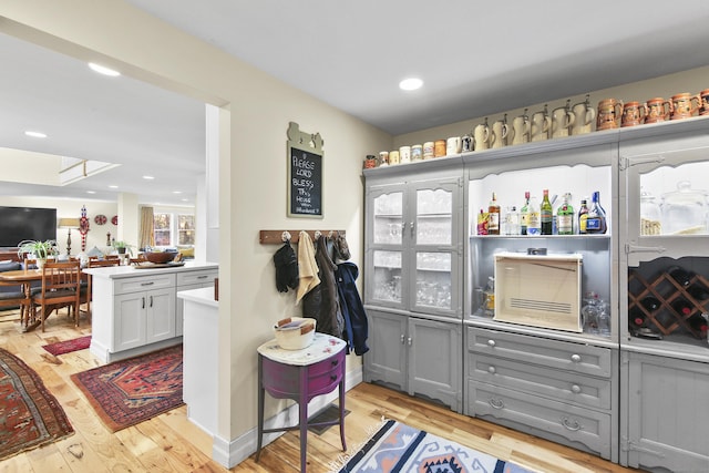 interior space featuring white cabinets, gray cabinets, and light hardwood / wood-style flooring