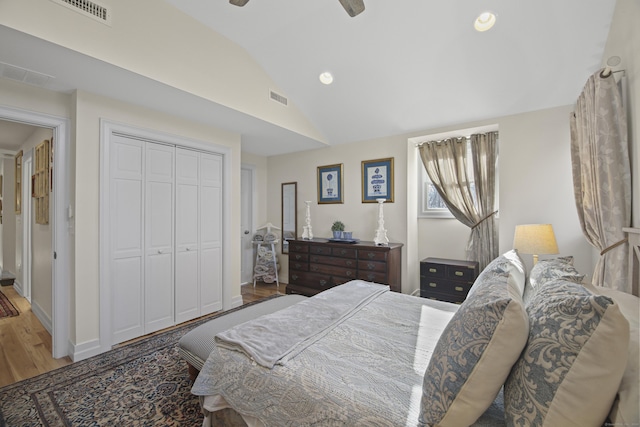 bedroom with ceiling fan, a closet, vaulted ceiling, and hardwood / wood-style flooring