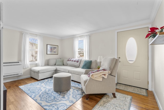 living room with hardwood / wood-style floors, a healthy amount of sunlight, and ornamental molding