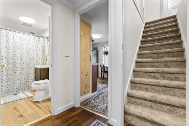 stairs with hardwood / wood-style floors, ornamental molding, and sink