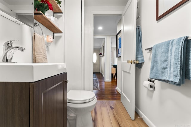 bathroom with hardwood / wood-style floors, vanity, and toilet