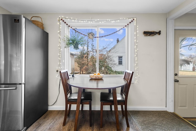 dining area with plenty of natural light and dark wood-type flooring