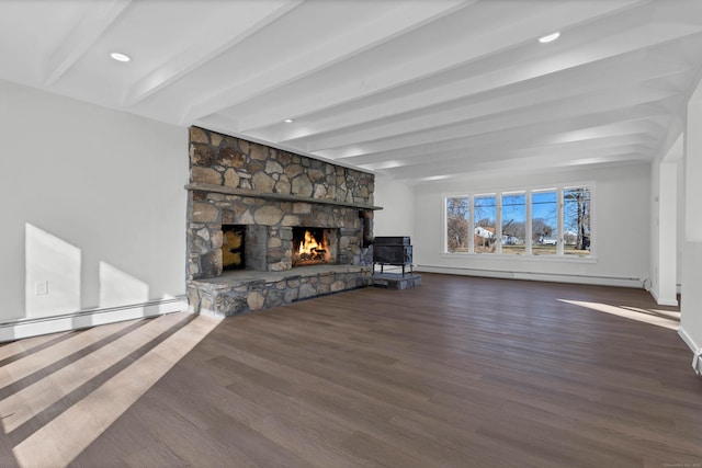 unfurnished living room featuring beamed ceiling, dark hardwood / wood-style floors, a stone fireplace, and a baseboard radiator