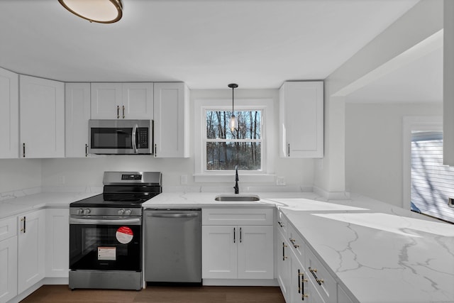 kitchen featuring white cabinets, pendant lighting, and stainless steel appliances