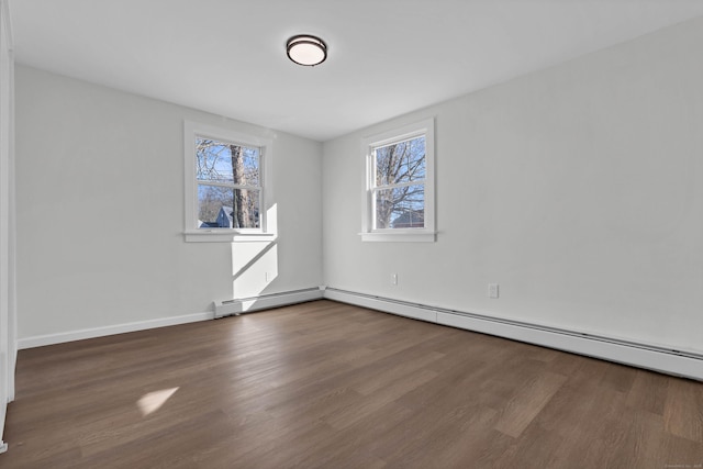 unfurnished room with hardwood / wood-style floors and a baseboard radiator