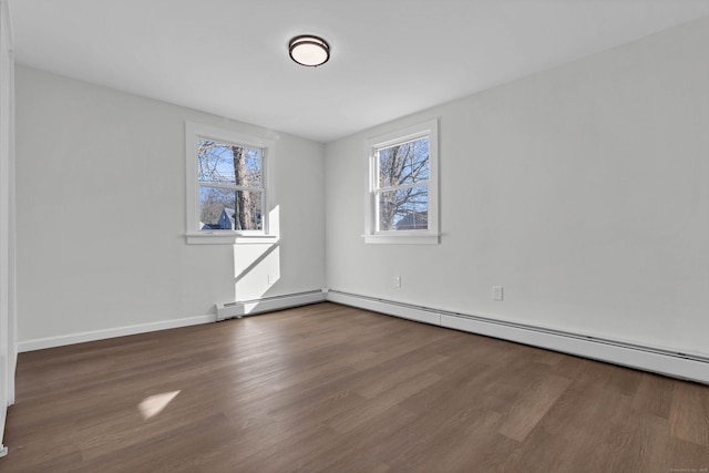 unfurnished room with baseboards, wood finished floors, and a baseboard radiator