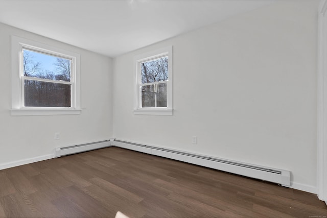 empty room with dark hardwood / wood-style flooring and a baseboard radiator