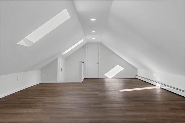 bonus room with baseboard heating, lofted ceiling with skylight, and dark wood-type flooring