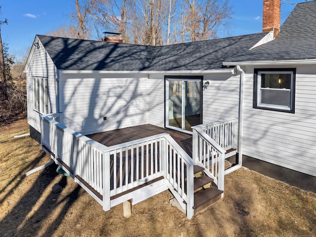 back of house featuring a deck, roof with shingles, and a chimney