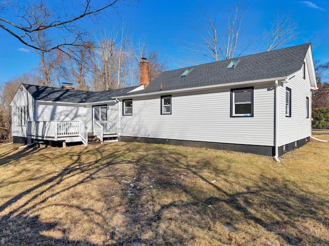 rear view of house with a lawn and a deck