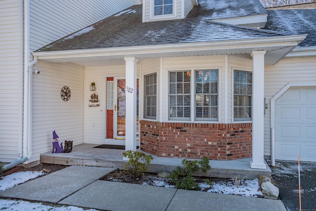 doorway to property with a porch and a garage