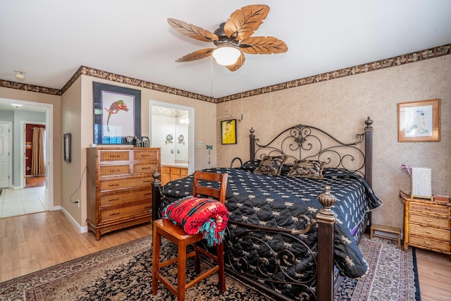 bedroom featuring hardwood / wood-style floors, ceiling fan, and connected bathroom