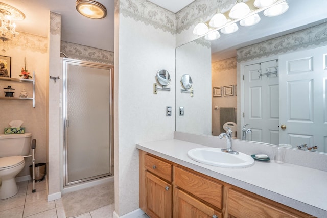 bathroom featuring tile patterned floors, vanity, toilet, and a shower with shower door