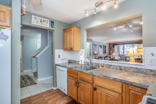 kitchen with backsplash, dishwasher, light tile patterned flooring, and sink