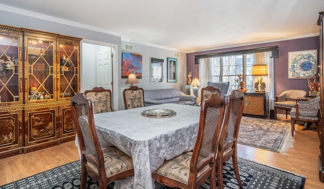 dining area featuring crown molding and hardwood / wood-style floors