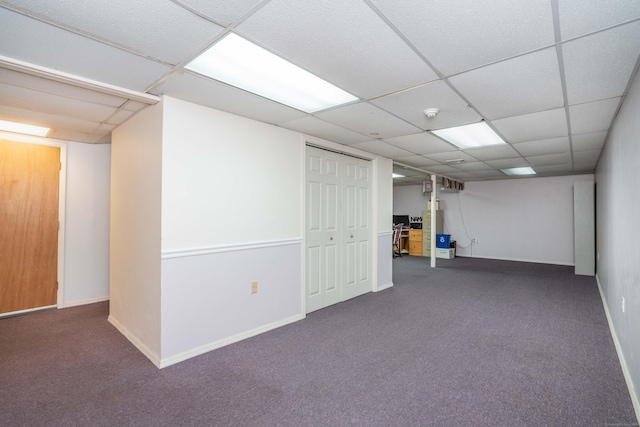 basement with dark carpet and a drop ceiling