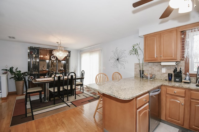 kitchen with a breakfast bar area, kitchen peninsula, plenty of natural light, and pendant lighting