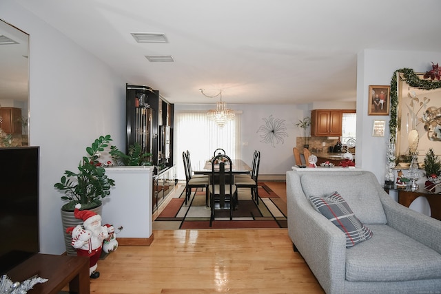 dining area with a chandelier and light hardwood / wood-style flooring