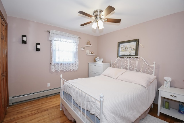 bedroom featuring ceiling fan, light hardwood / wood-style floors, and a baseboard radiator