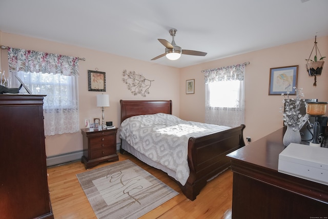 bedroom featuring ceiling fan, a baseboard radiator, and light wood-type flooring