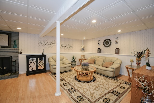 living room with hardwood / wood-style floors and a brick fireplace