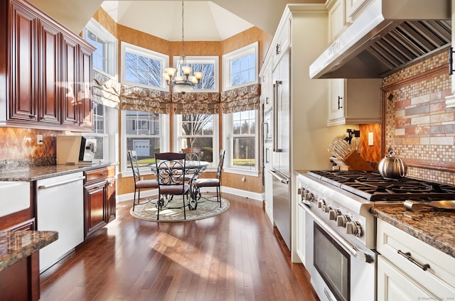 kitchen with dishwasher, ventilation hood, high end stove, a chandelier, and pendant lighting