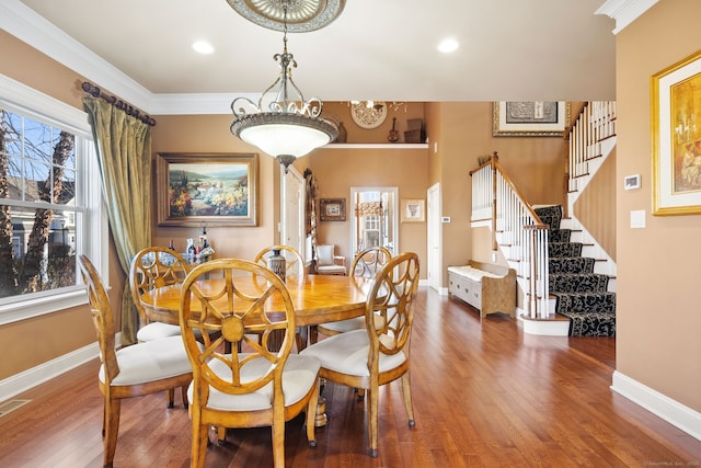 dining space featuring wood-type flooring, plenty of natural light, and ornamental molding