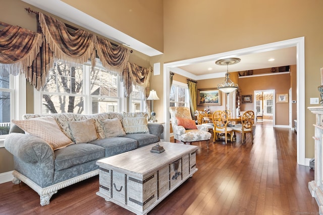 living room with ornamental molding and dark wood-type flooring