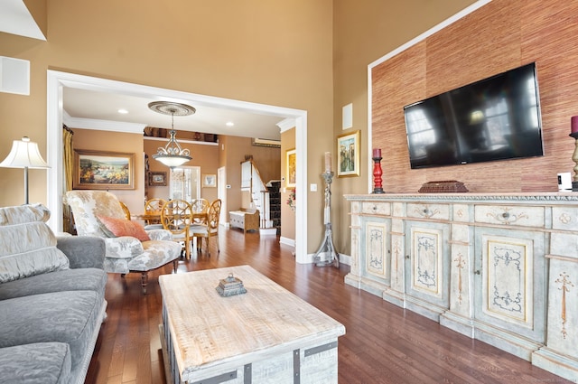 living room with an AC wall unit, dark wood-type flooring, and ornamental molding