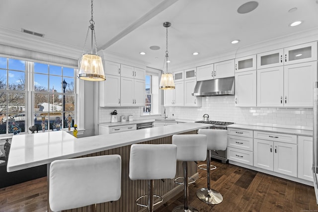 kitchen with under cabinet range hood, white cabinets, and light countertops