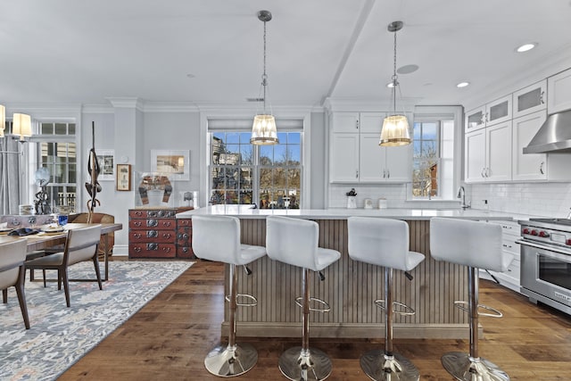 kitchen with a center island, designer range, light countertops, glass insert cabinets, and white cabinets