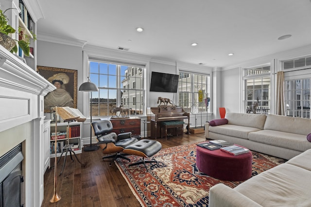 living room with a fireplace, dark wood finished floors, crown molding, and recessed lighting