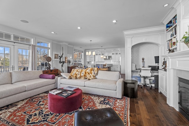 living area with ornamental molding, dark wood finished floors, a fireplace, and recessed lighting