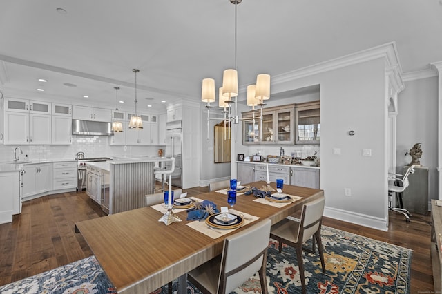 dining space with ornamental molding, dark wood-style flooring, a chandelier, and baseboards