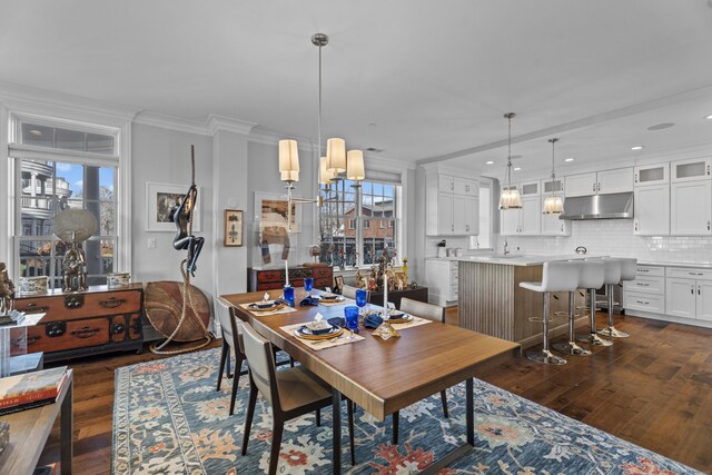 dining area featuring a healthy amount of sunlight, ornamental molding, dark wood finished floors, and a notable chandelier