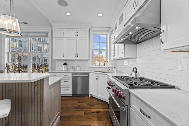 kitchen featuring extractor fan, a sink, white cabinets, hanging light fixtures, and appliances with stainless steel finishes