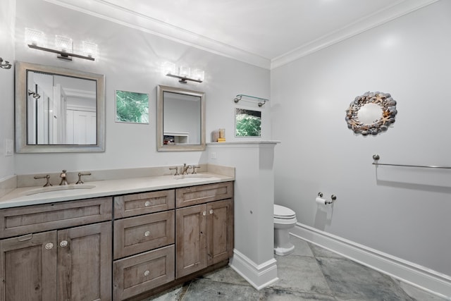 bathroom featuring ornamental molding, a sink, toilet, and baseboards