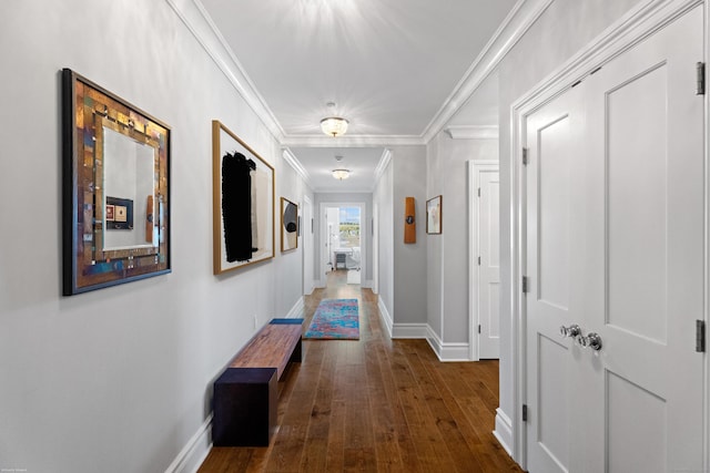 corridor featuring dark wood-style floors, baseboards, and crown molding