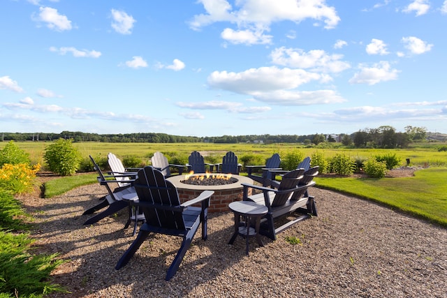 view of yard featuring an outdoor fire pit and a rural view