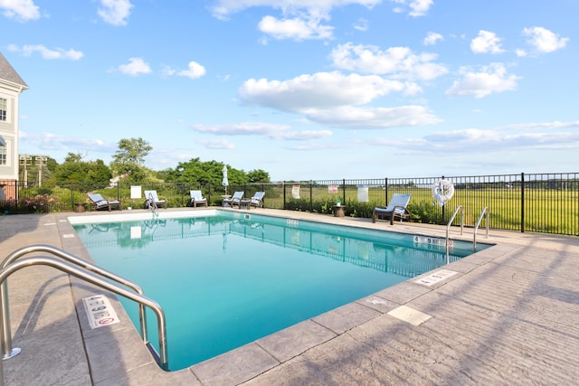 community pool with fence and a patio