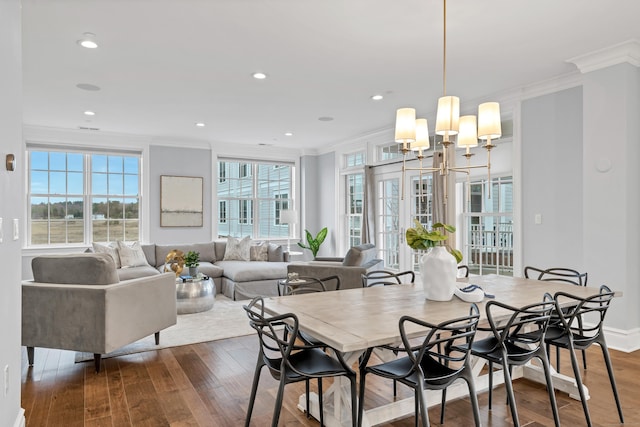 dining area with dark wood-style flooring, ornamental molding, a wealth of natural light, and recessed lighting