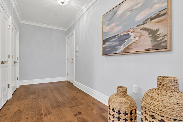 hall with baseboards, crown molding, and wood finished floors
