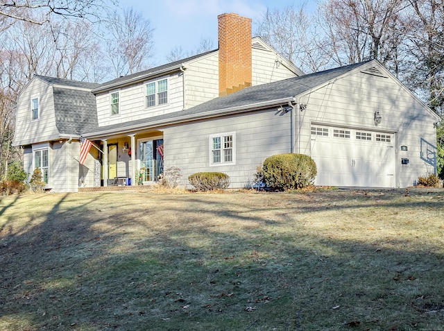 rear view of property with a yard and a garage