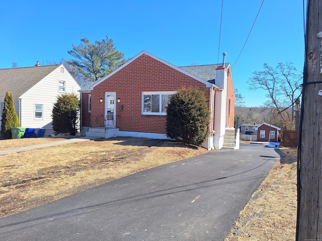 exterior space with brick siding and a chimney