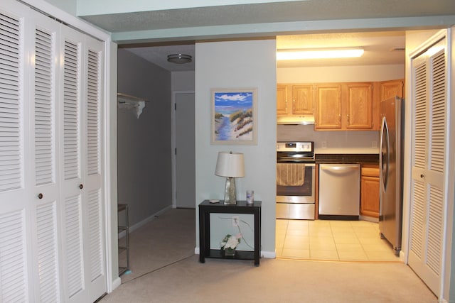 kitchen featuring light colored carpet, light brown cabinetry, and appliances with stainless steel finishes