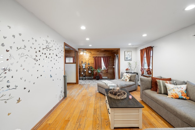 living room with wooden walls and light wood-type flooring