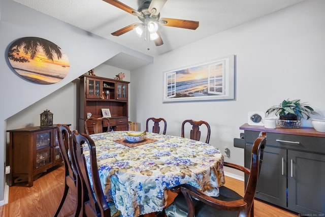 dining space with light wood-type flooring and ceiling fan