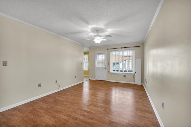 unfurnished room with ceiling fan, wood-type flooring, a textured ceiling, and ornamental molding