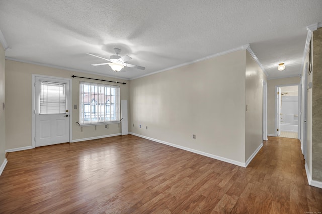 empty room featuring a textured ceiling, hardwood / wood-style flooring, ceiling fan, and ornamental molding