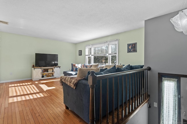 living room with wood-type flooring and a textured ceiling